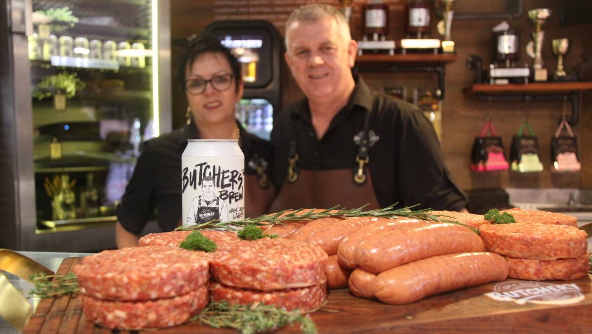 Julie and Rod Laver with examples of their first-placed lamb and halloumi burger and second-placed traditional Australian beef sausage at the recent AMIC Sausage King held in Brisbane on October 21, 2023. Their licensed store also sells their own beer, Butchers Brew, as well as boutique wine and spirits. Picture by Alison Paterson.
