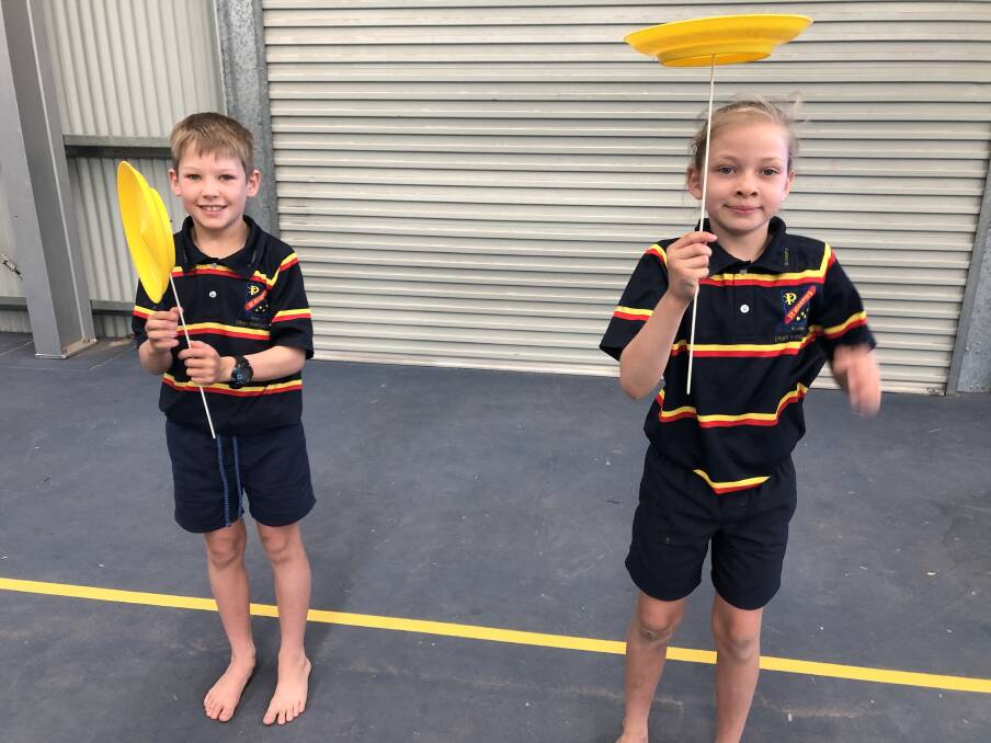 Ethan Kelly and Lucy Burgess twirling tops at a circus workshop at St Joseph's School, Blackall, funded by emergent COVID-19 recovery money.
