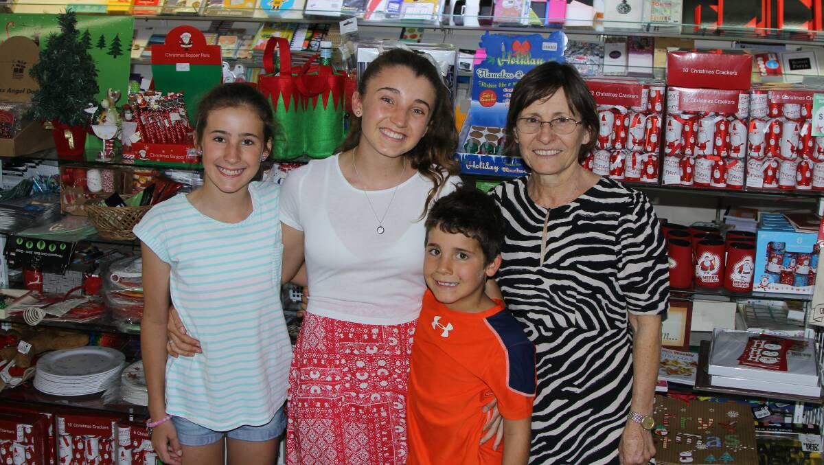 Christmas cheer: Keren Greenhalgh, right and three of her grandchildren, Abbie, Kasey and Jed Lane, helping out in the Blackall Newsagency in the lead-up to Christmas Day. Picture: Sally Cripps.