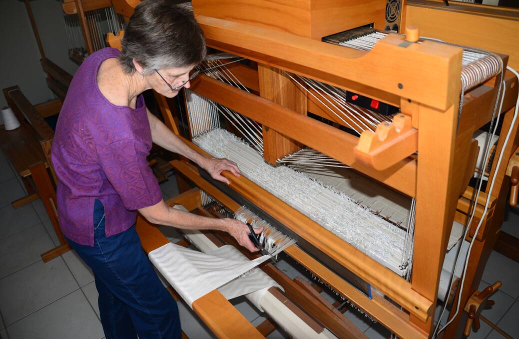 FINAL SNIP: Birkdale weaver Kay Faulkner cuts off the last fabric woven for scarves for female High Court judges.