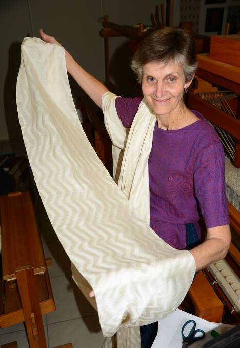 WEAVER MAGIC: Birkdale weaver Kay Faulkner with the scarf fabric showing silk and wool in a ripple shape. The robes cost $32,900 and will be passed on to other judges.