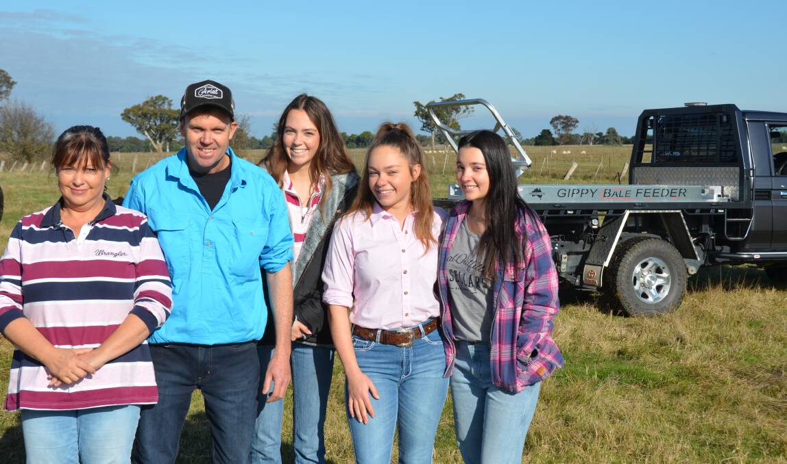 The Higgins family stand on a paddock at Briagolong after using the Gippy Bale Feeder.