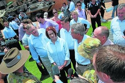 Prime Minister Julia Gillard speaks with army personnel during her visit to Bundaberg after the floods last week.