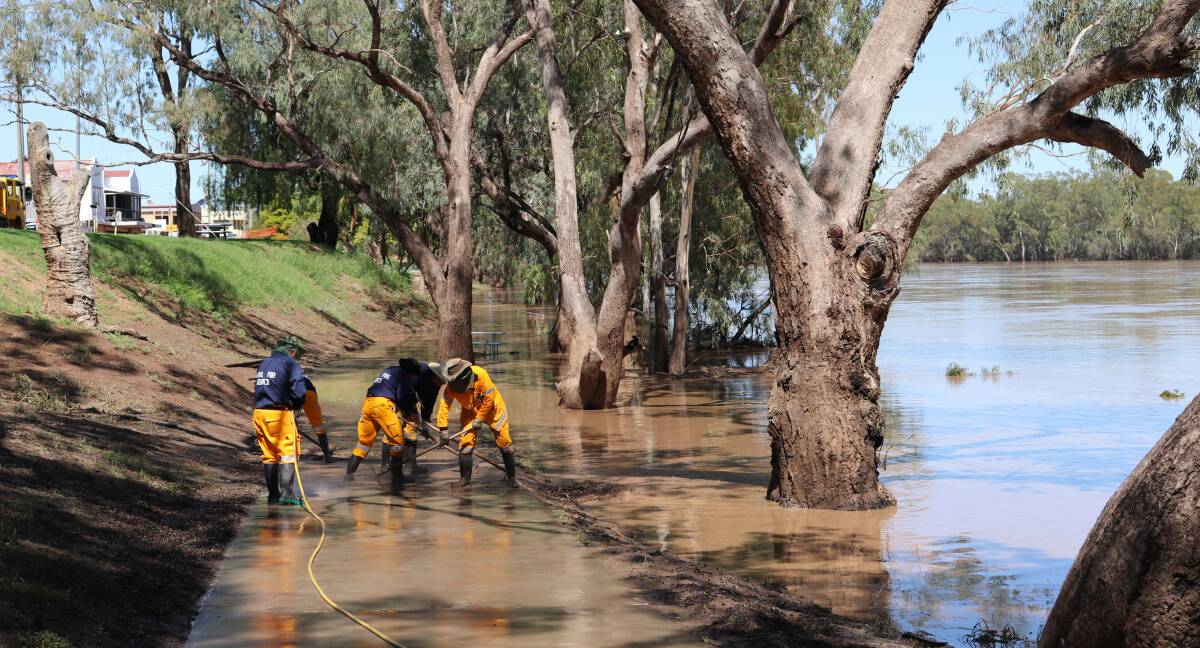 Clean Up: The Roma Rural Fire Service volunteers lent a helping hand at St George to wash all the slush and mud from the Balonne River bank. Picture: Julie Davies
